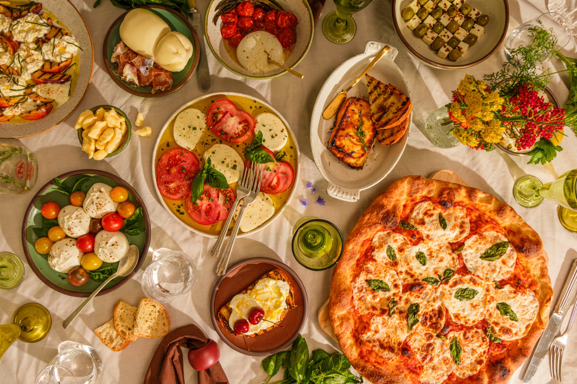 A table of Maplebrook cheeses, caprese, and pizza